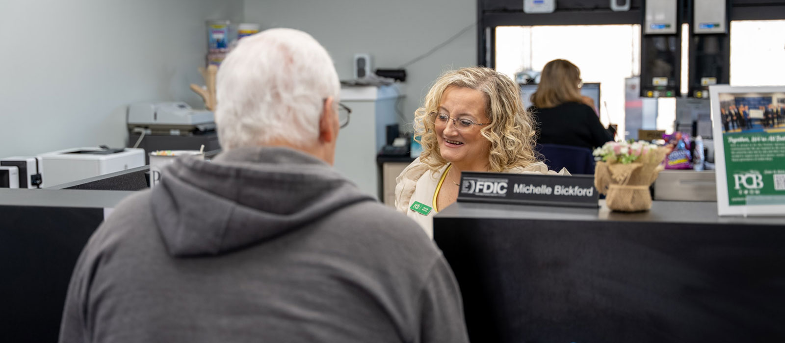 A bank employee greeting a customer