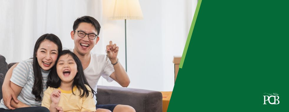 Asian family sitting on a couch laughing