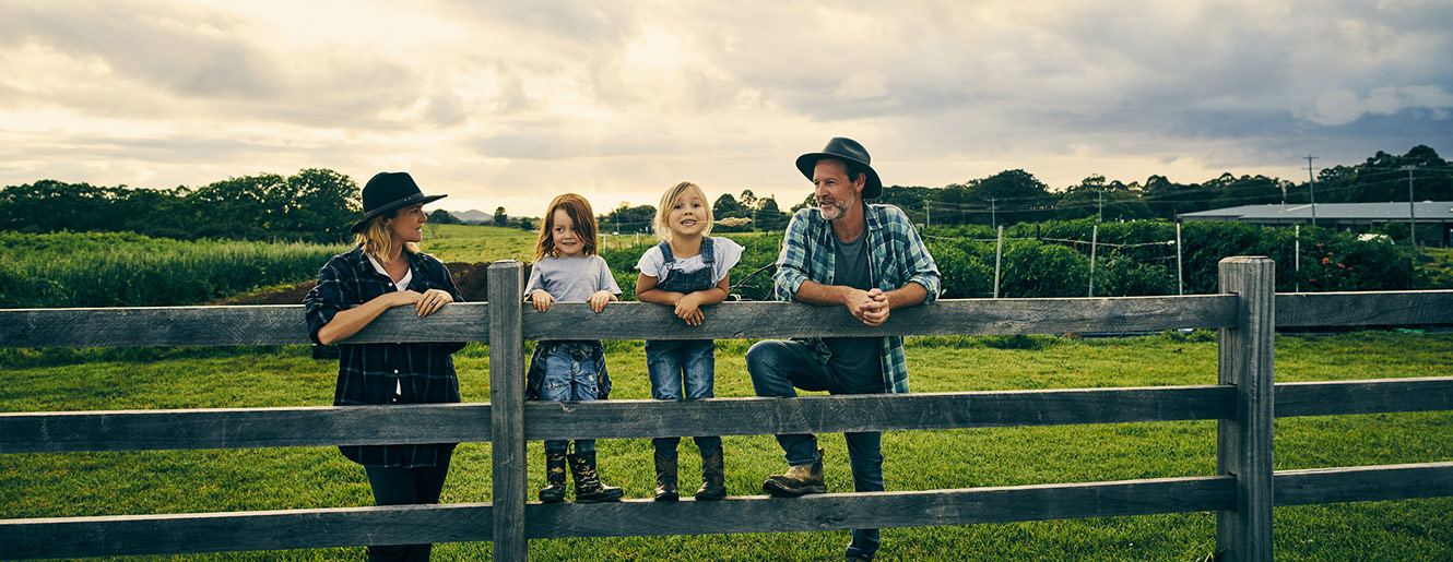 Family at a fence on a farm