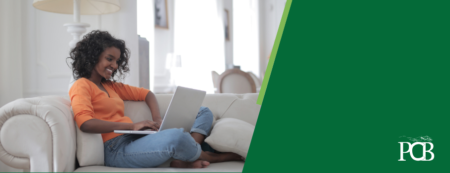 woman sitting on her couch looking at a laptop
